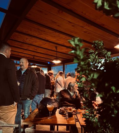 Groupe de personnes discutant dans un café en extérieur, ambiance conviviale.