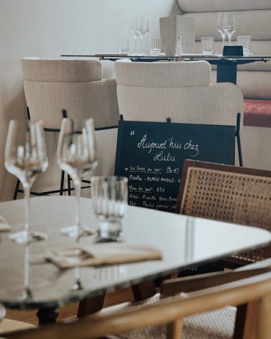 Table dressée avec des verres de vin et un tableau noir au restaurant élégant.