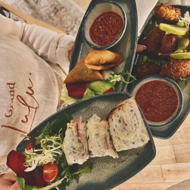 Assiette de plats variés avec salade, sauces et garnitures savoureuses.